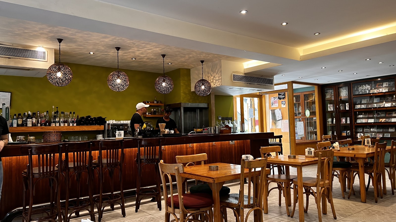 The T-Marbouta dining room, olive green walls and a long wooden bar