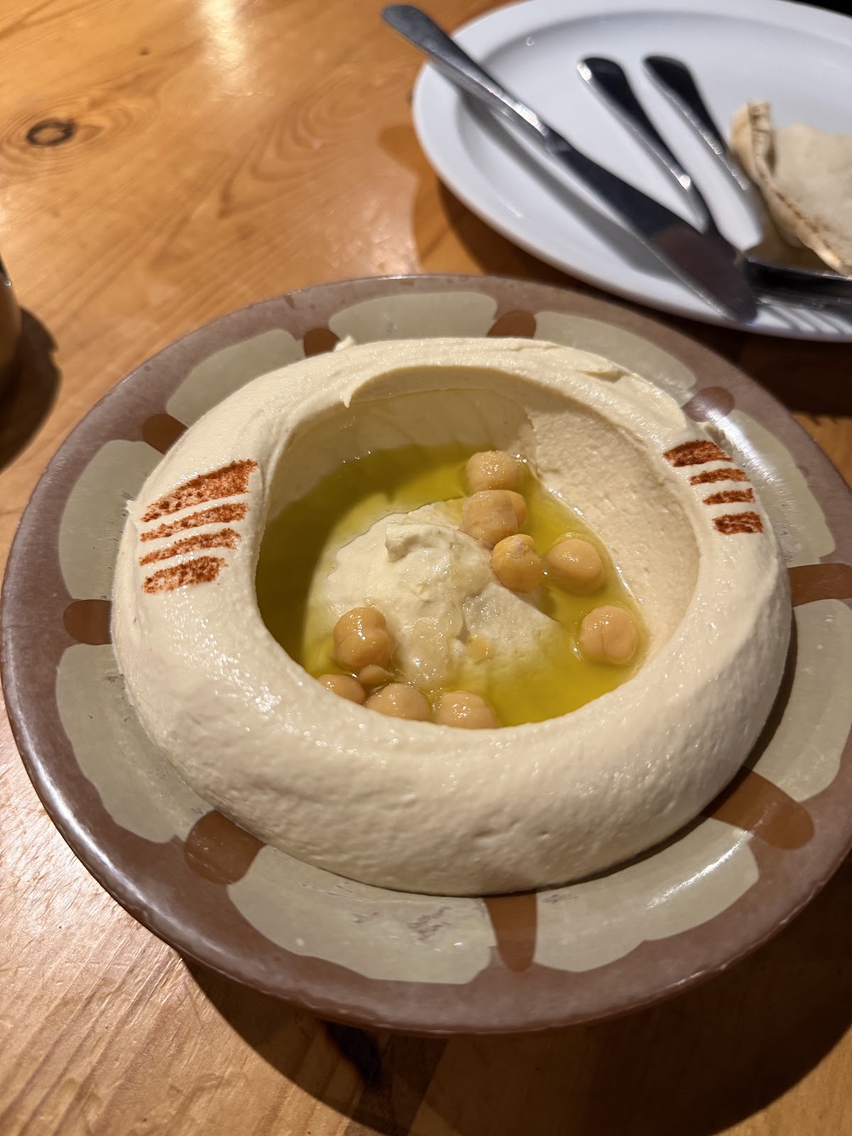Hummus with pine nuts in a clay bowl
