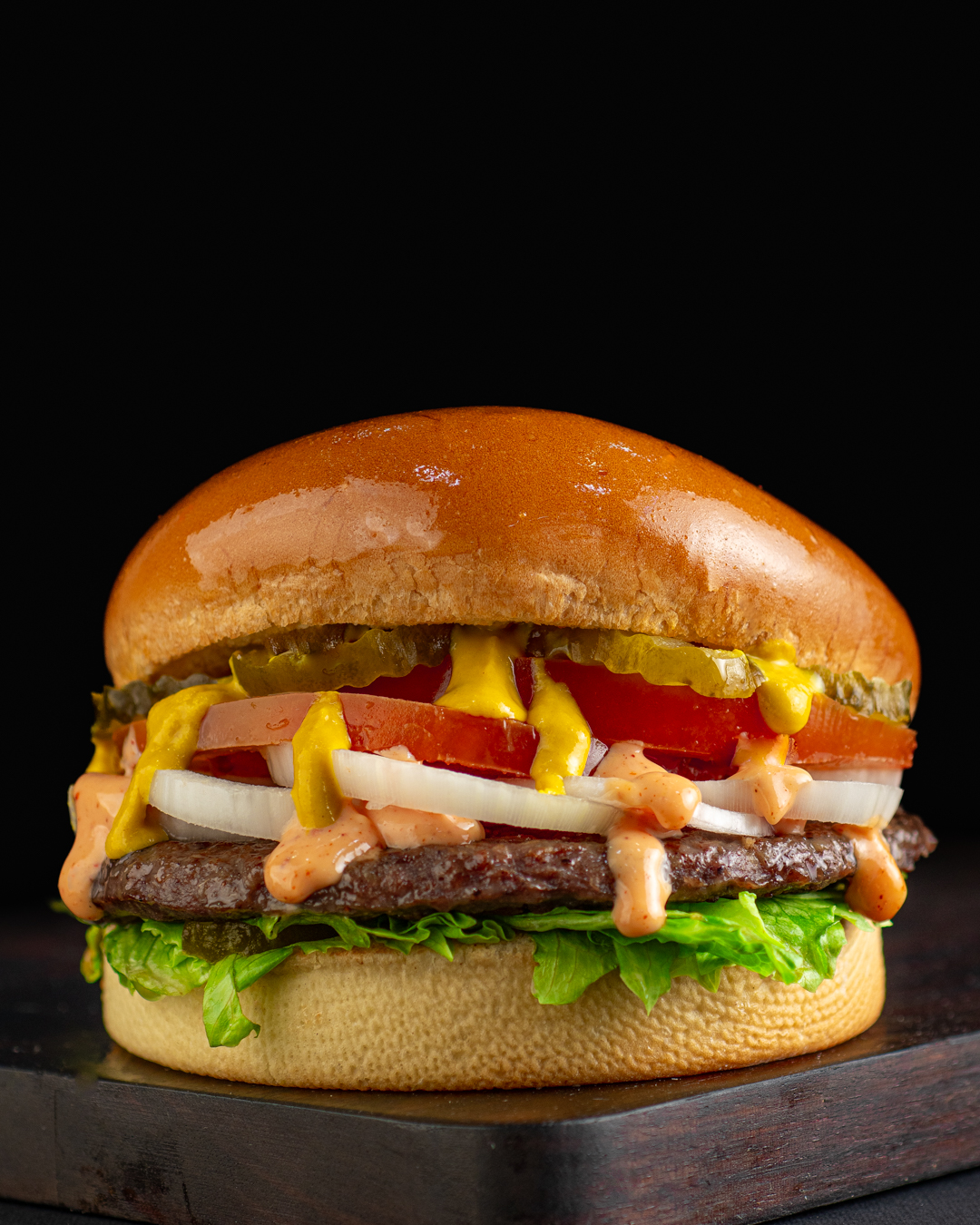 A Tolido Snack burger photographed on a dark ground