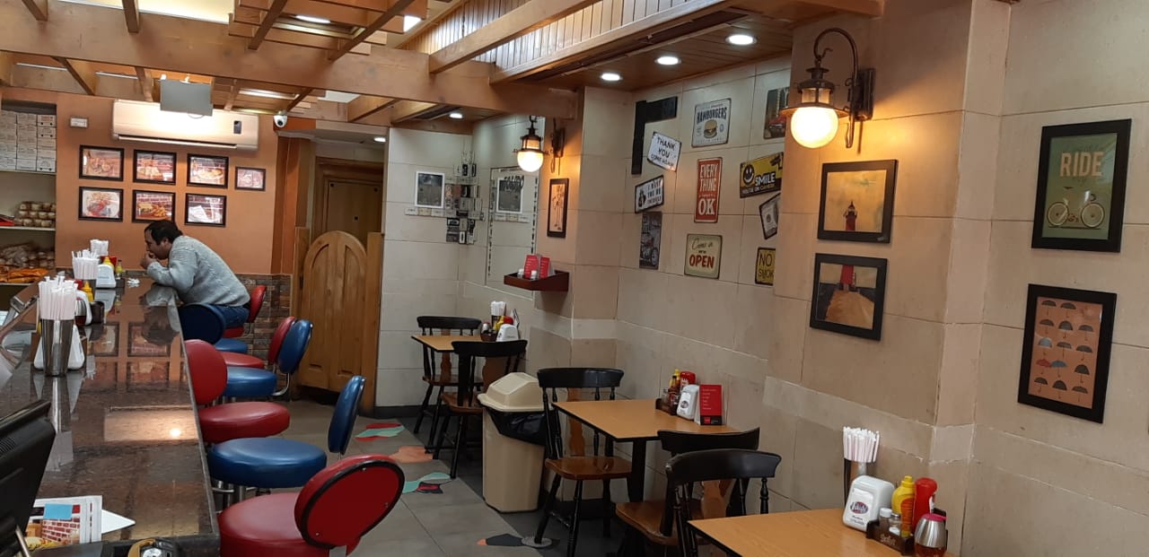 The Tolido dining room with red stools and framed pictures