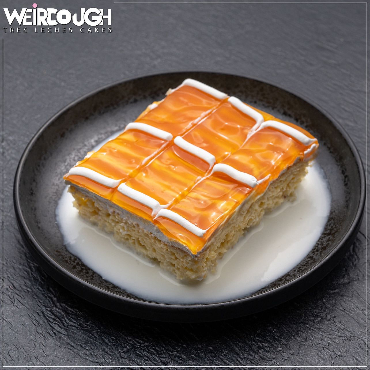 A single slice of caramel tres leches on a dark plate