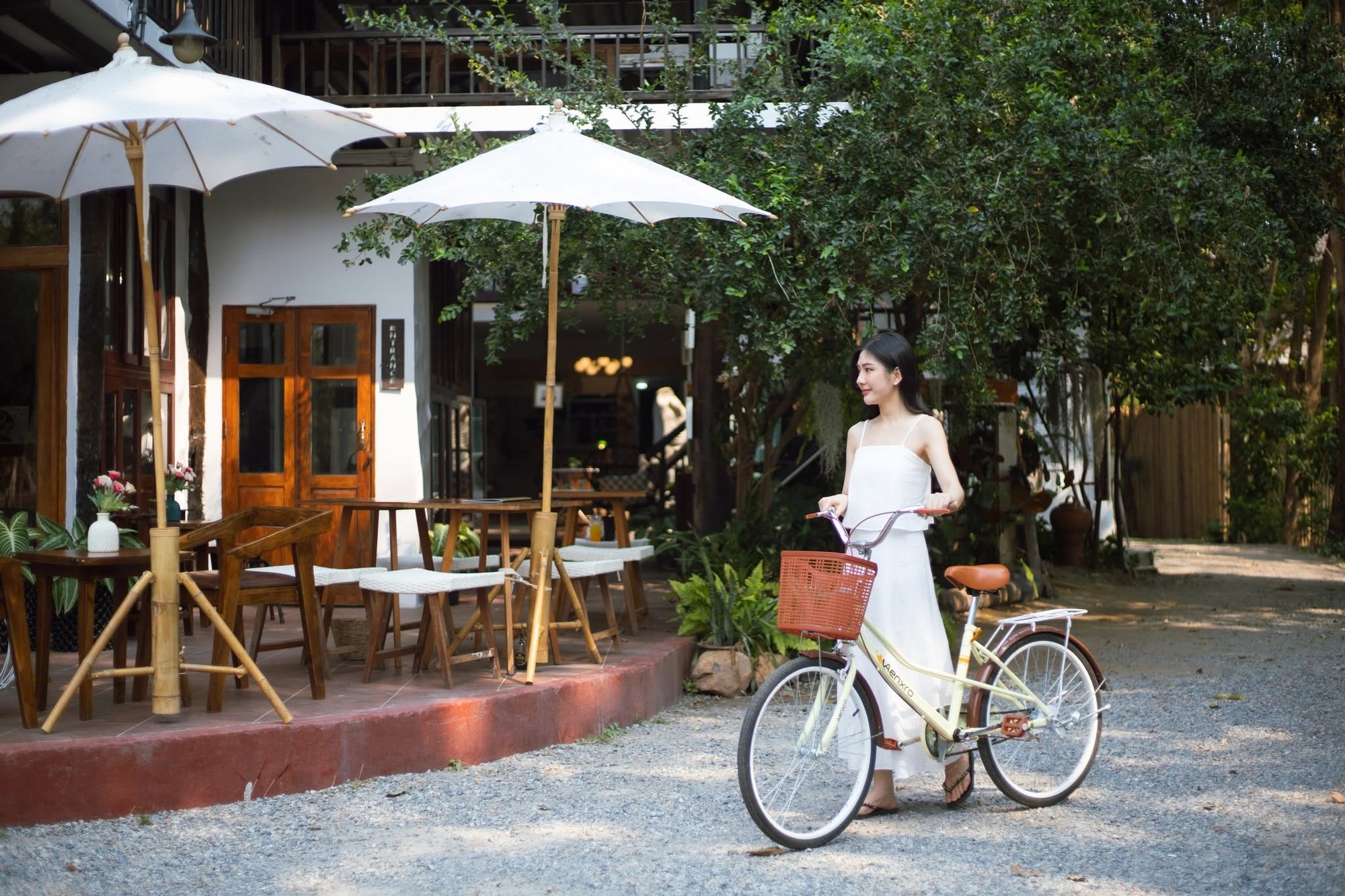 The OON Café garden at Ob-Un Homestay, with white parasols and teak seating