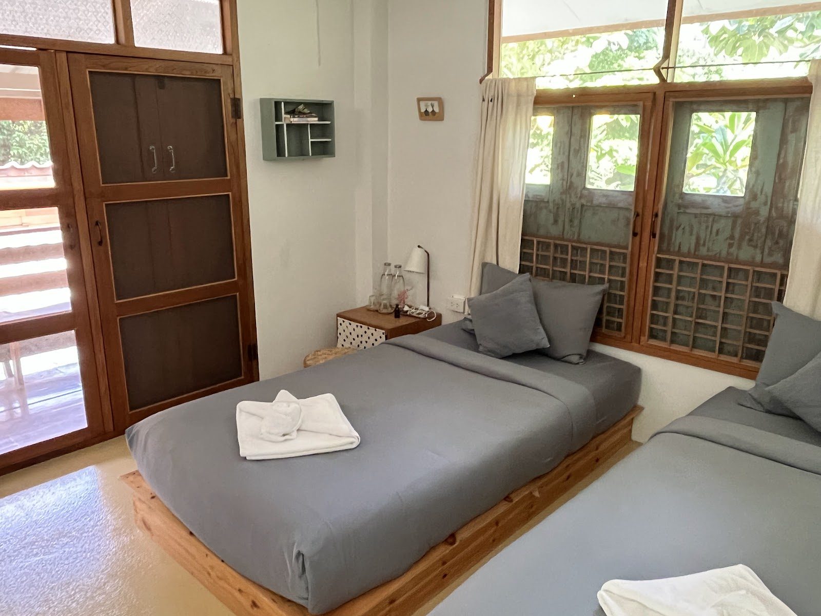 Clean twin room with wooden doors at Pai Yan Noi