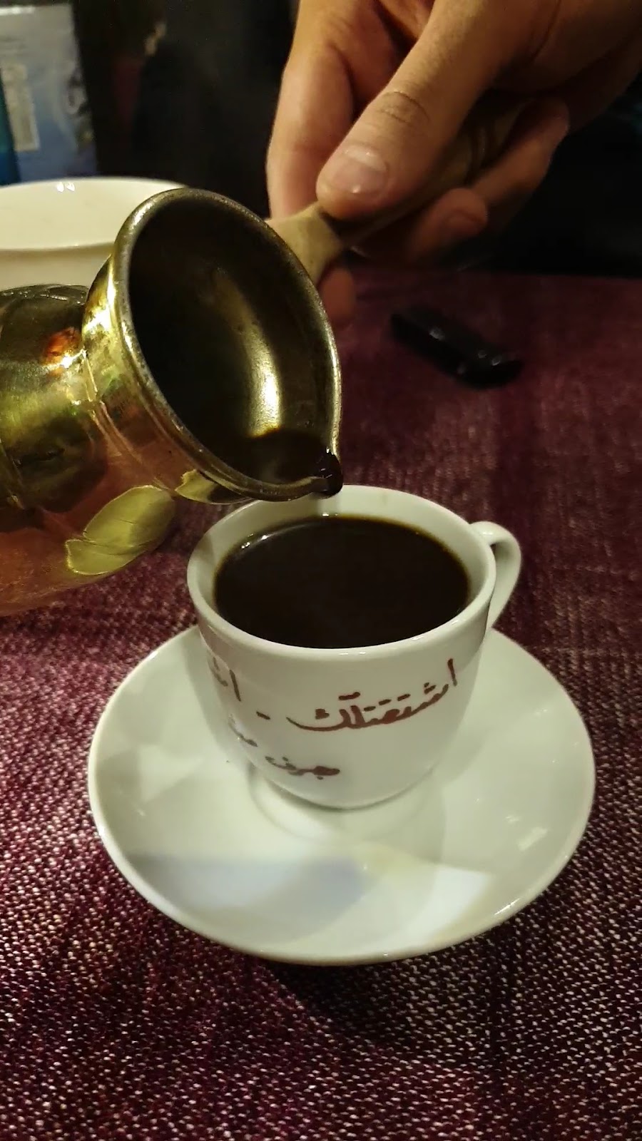 صبّ القهوة من الدلة في فنجان الشعر
