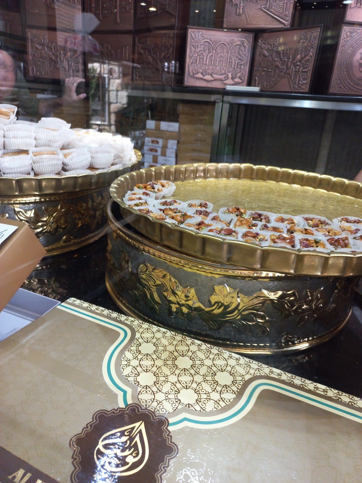 صواني نحاسية مزخرفة عليها حلويات