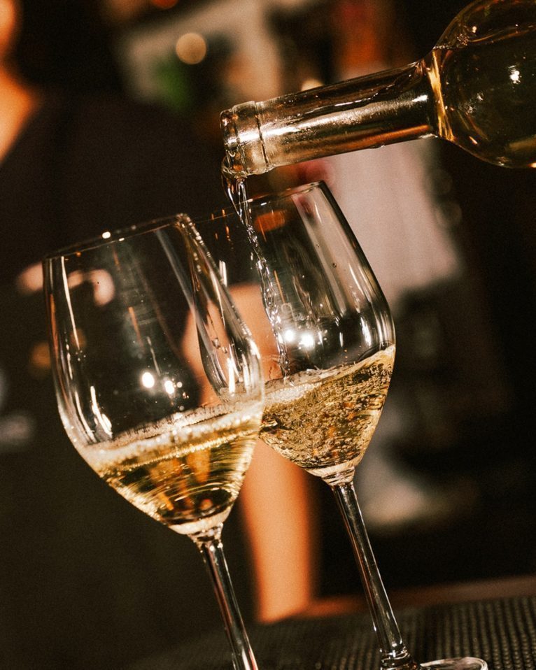 White wine poured into two glasses at the CORKS counter