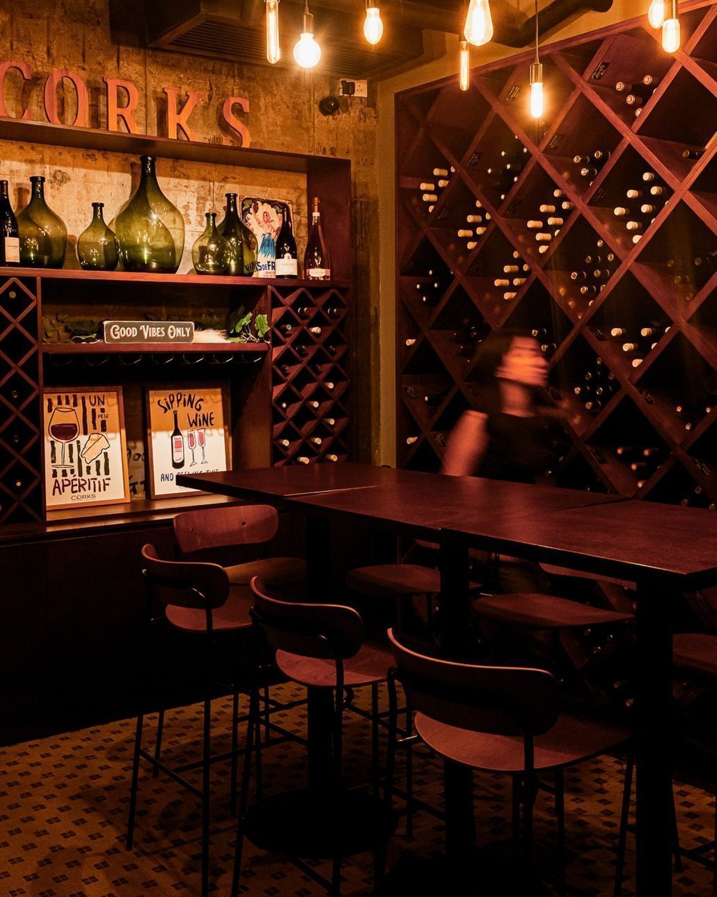 The CORKS room: wine racks, the house sign and the long table