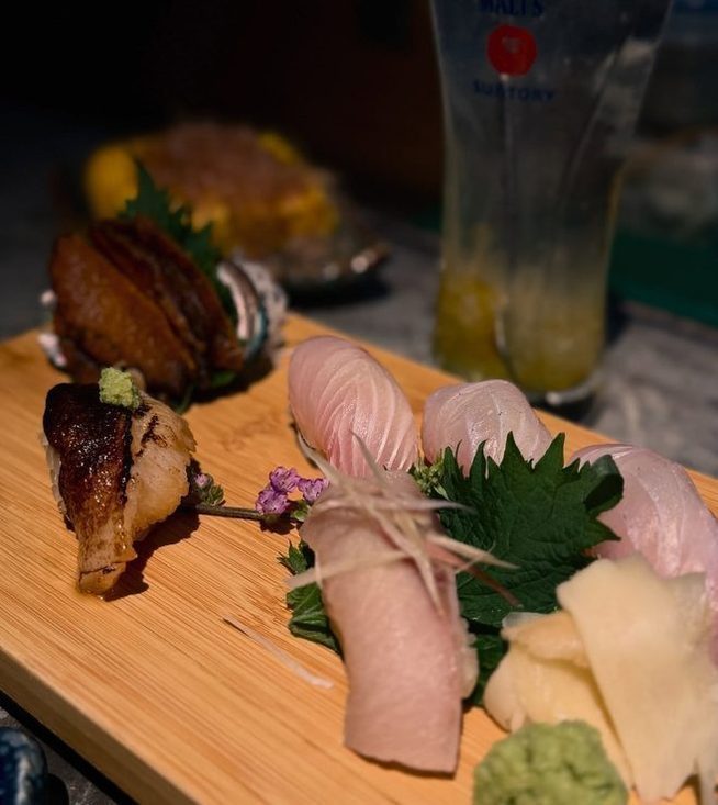 A sashimi platter on the wooden board at Kuki Izakaya