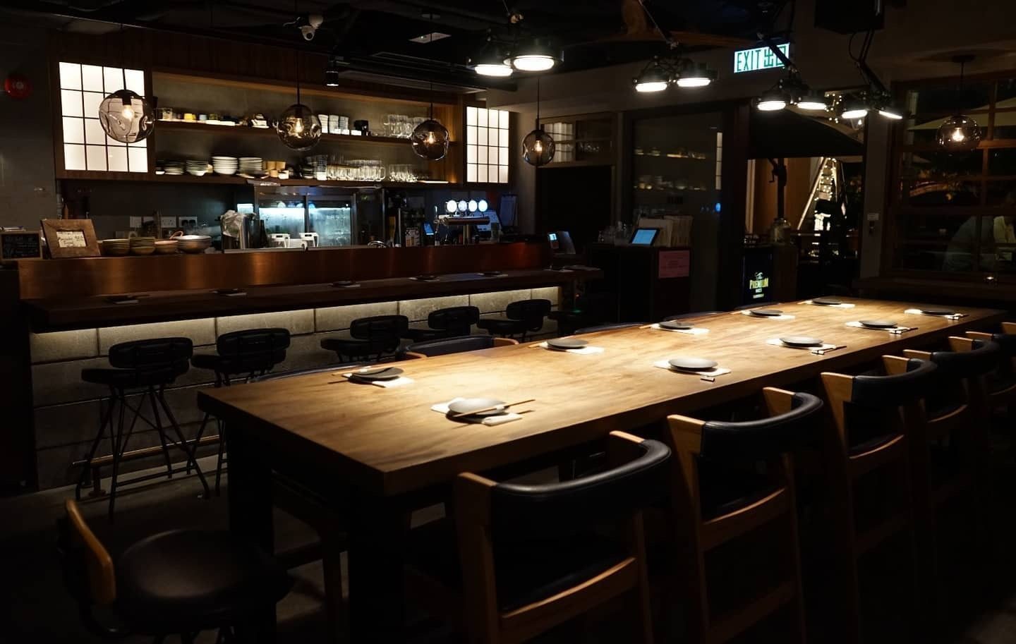The long communal table at NOJO, laid and lit before service