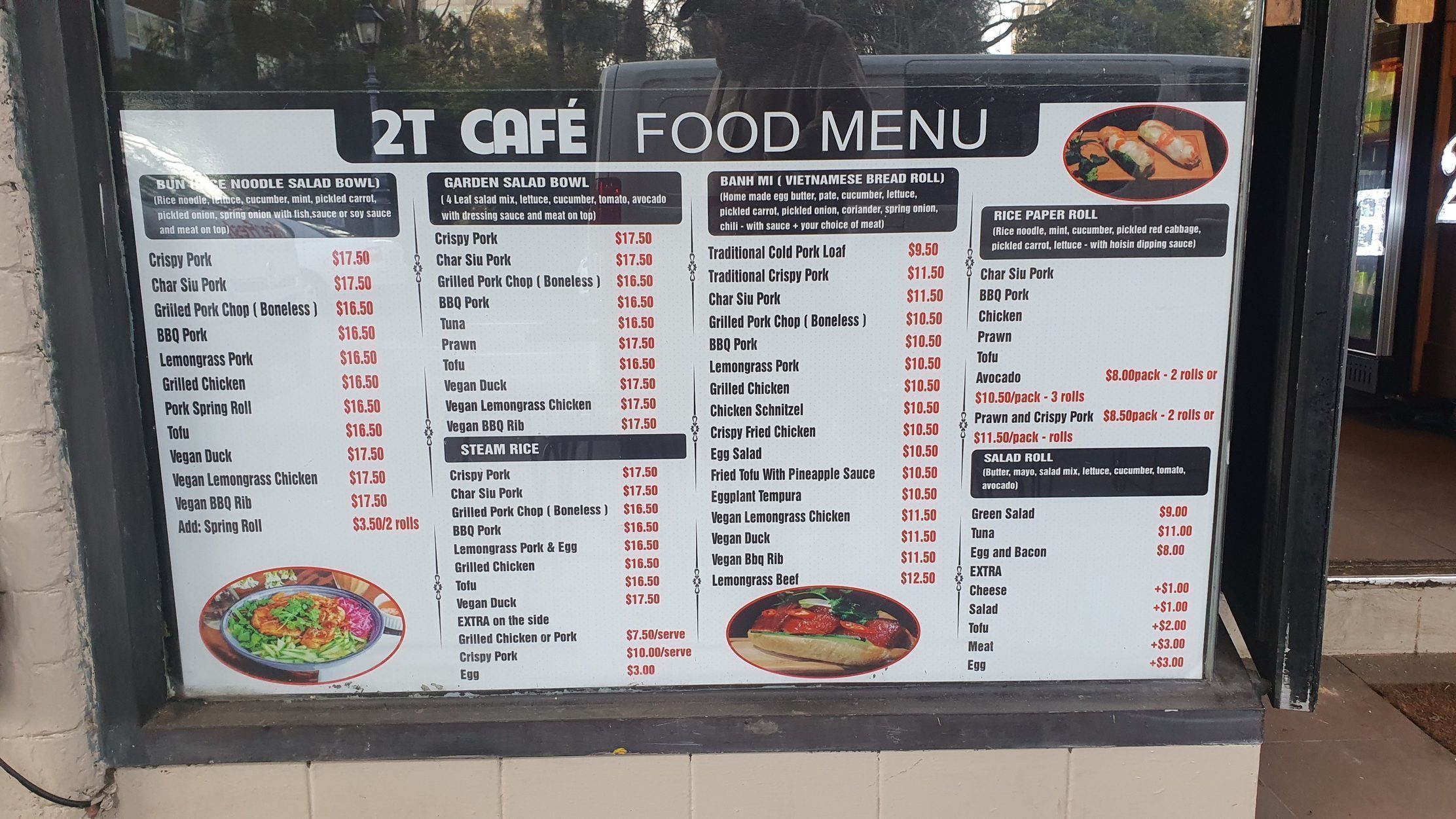 The 2T Cafe food menu board in the window: bánh mì, bún, steam rice, salads and rice paper rolls with prices