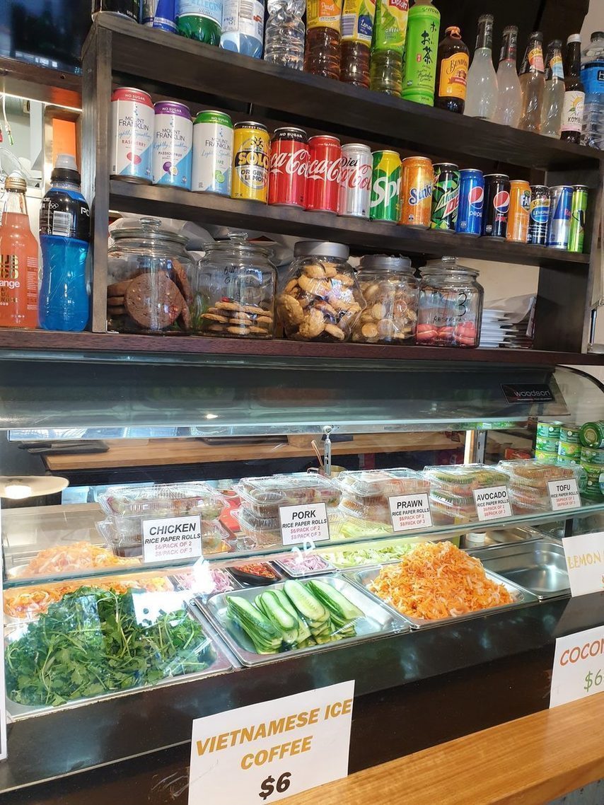 The 2T Cafe cabinet stacked with rice paper rolls, herbs, pickles and cold drinks