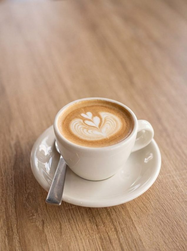 Flat white with latte art on a timber table