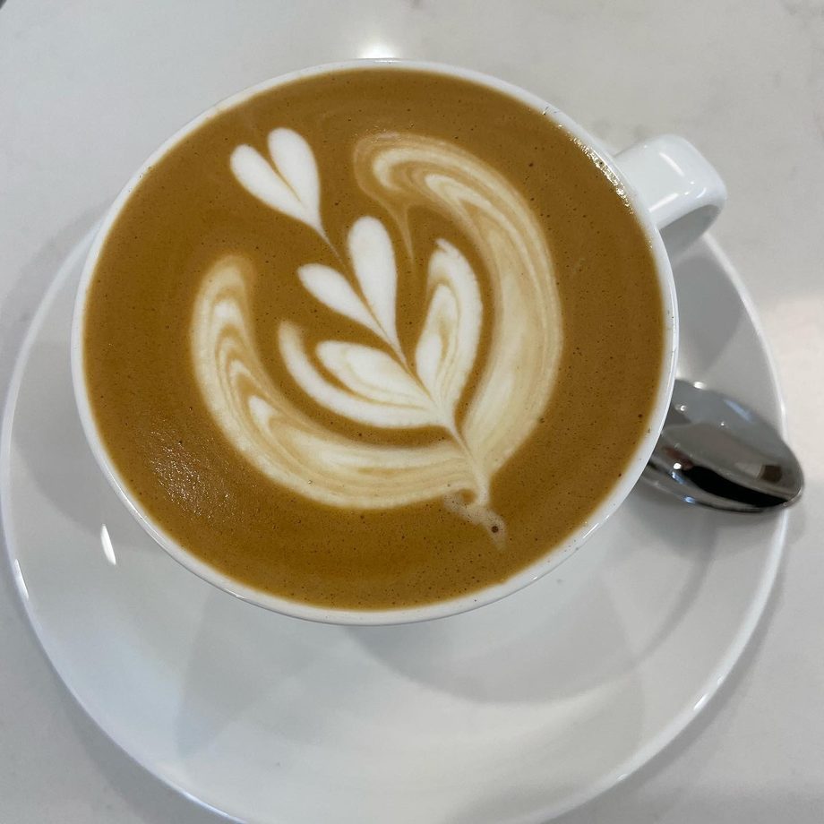 A coffee with latte art in a white cup at Heart Coffee
