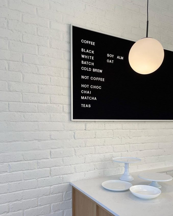The Heart Coffee menu board on the white brick wall