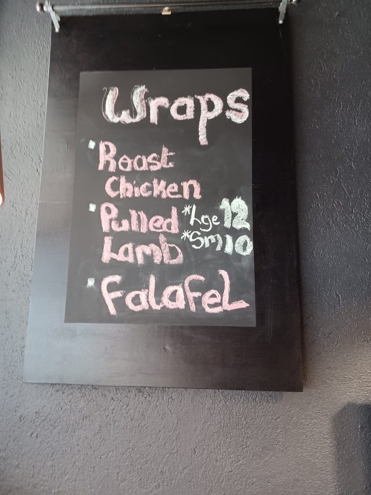The Little Bridge chalkboard listing wraps: roast chicken, pulled lamb and falafel, large twelve dollars, small ten dollars