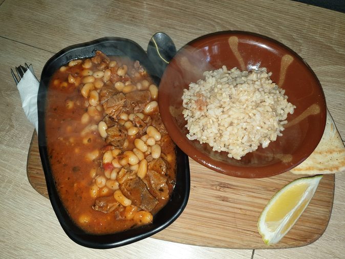 Fasolia, a slow lamb and white bean stew in tomato, served with rice, flatbread and lemon